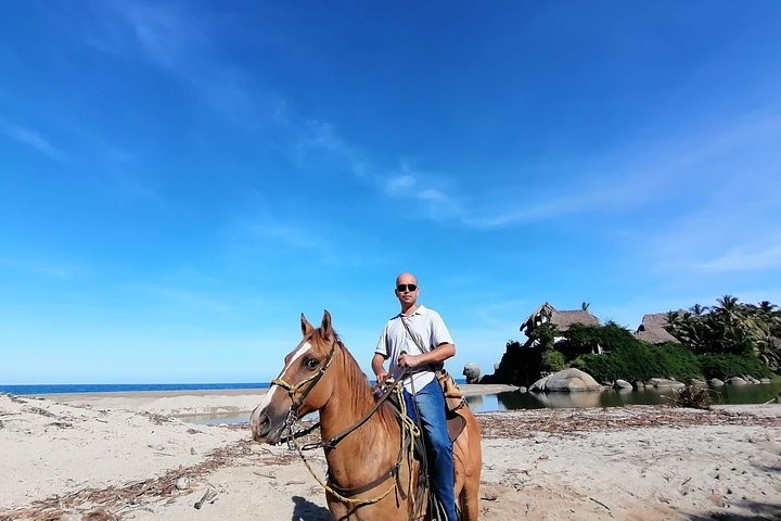 Colombian visitor, in the background the river stones, the sea and the cabins of the windward hotel.