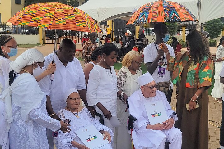 An elderly African American after their traditional naming ceremony with their certificates 