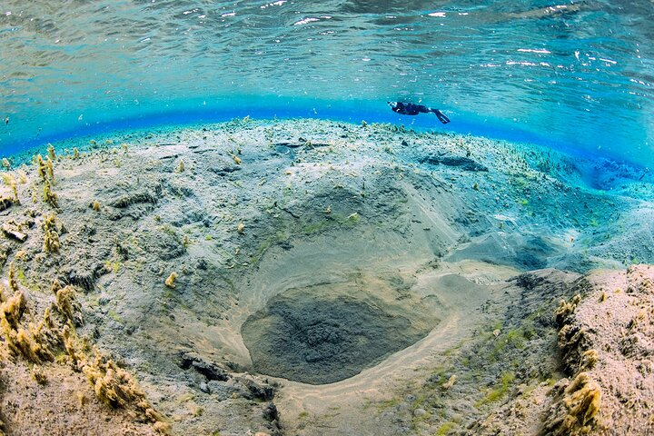 Bubbling sands dancing and a snorkeler floating above