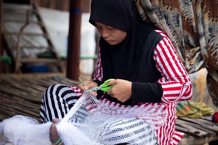 Muslim villager weaving fishing net