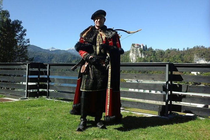 starting point of the walking tour at the terrace of the hotel Kompas with the castle, lake and Julian Alps as a backdrop