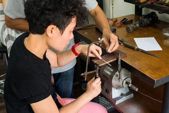 Sawing a piece of silver to make into a ring band.