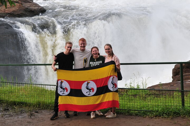 Tourist holding Uganda flag at Murchison falls